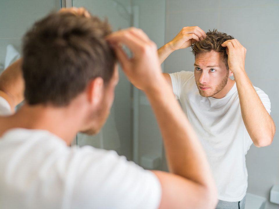 Homme constatant qu'il perd ses cheveux