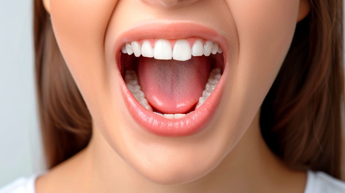 Vue rapprochée d'une bouche saine montrant des dents et une langue, représentant la santé des glandes salivaires